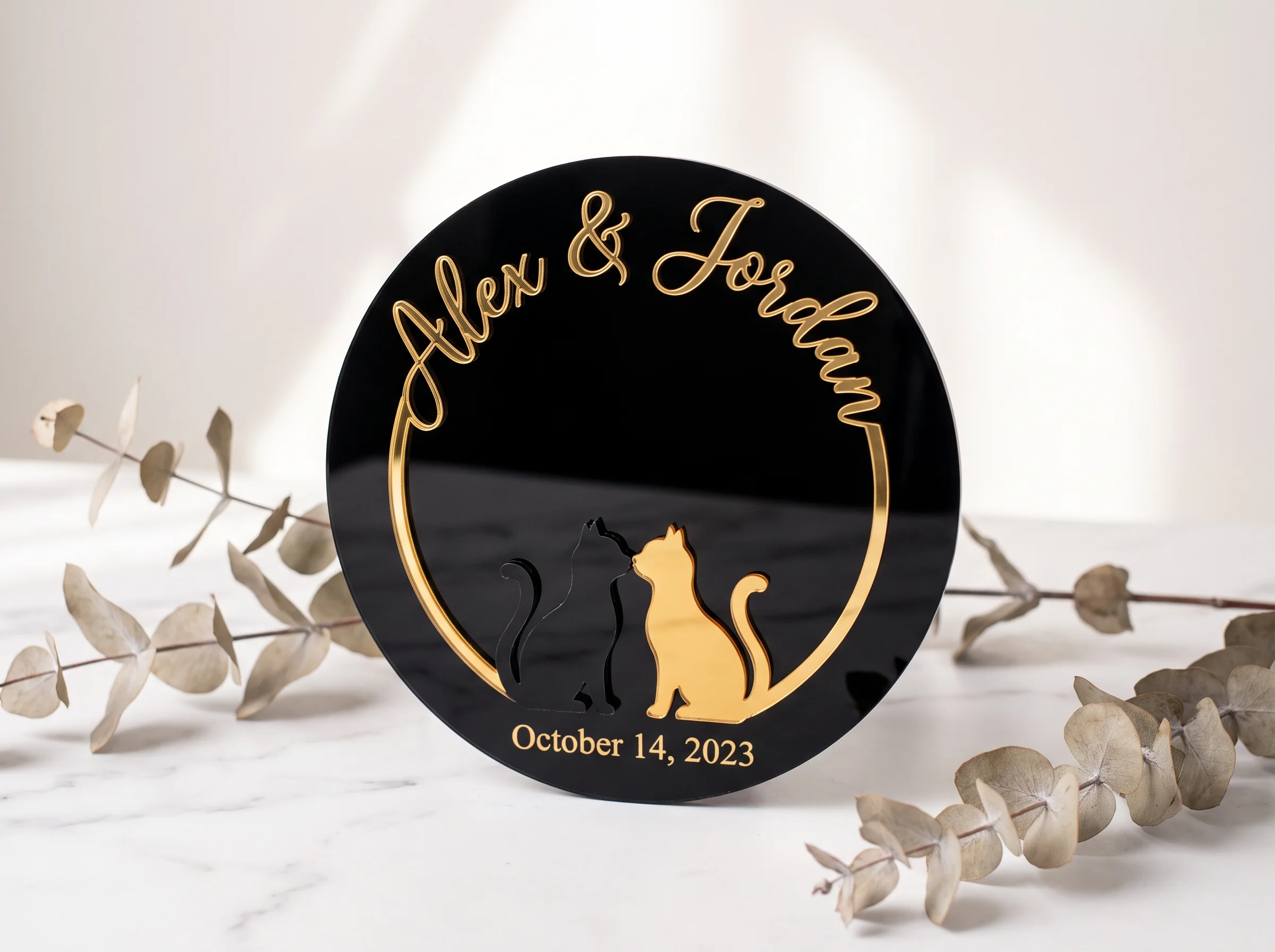 Black acrylic cat wedding cake topper with two kissing cat silhouettes and gold script lettering