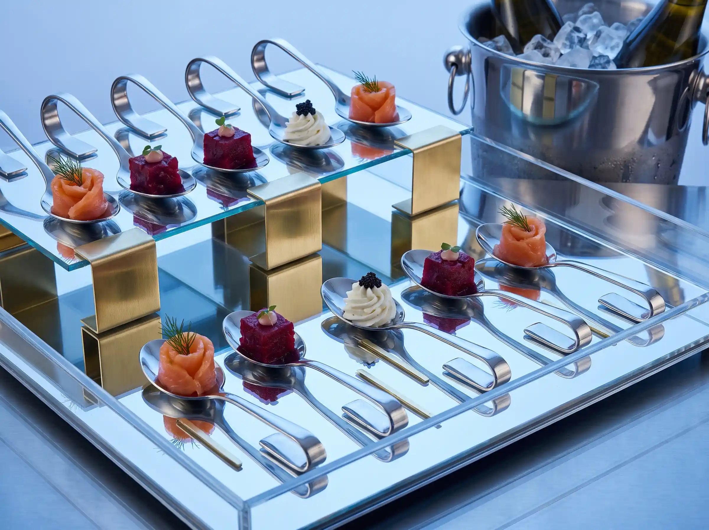 Mirrored acrylic tray with single bite spoon canapes of smoked salmon beet tartare and goat cheese swirls