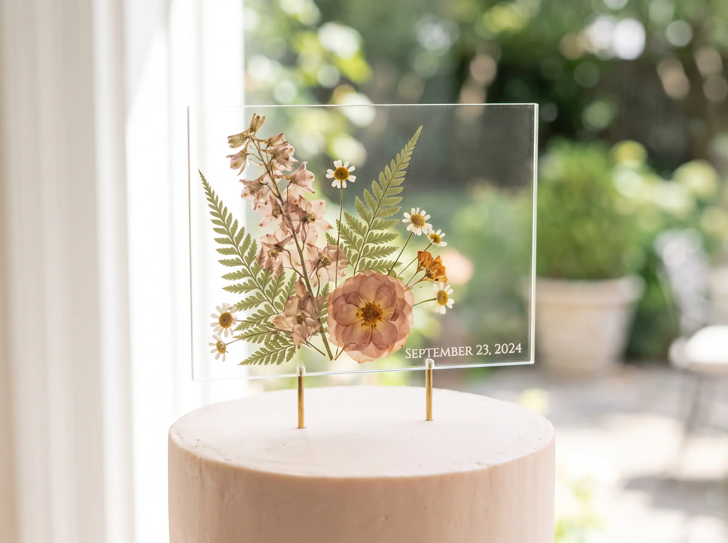 Clear acrylic cake topper with pressed wildflowers ferns and wedding date on pale garden cake