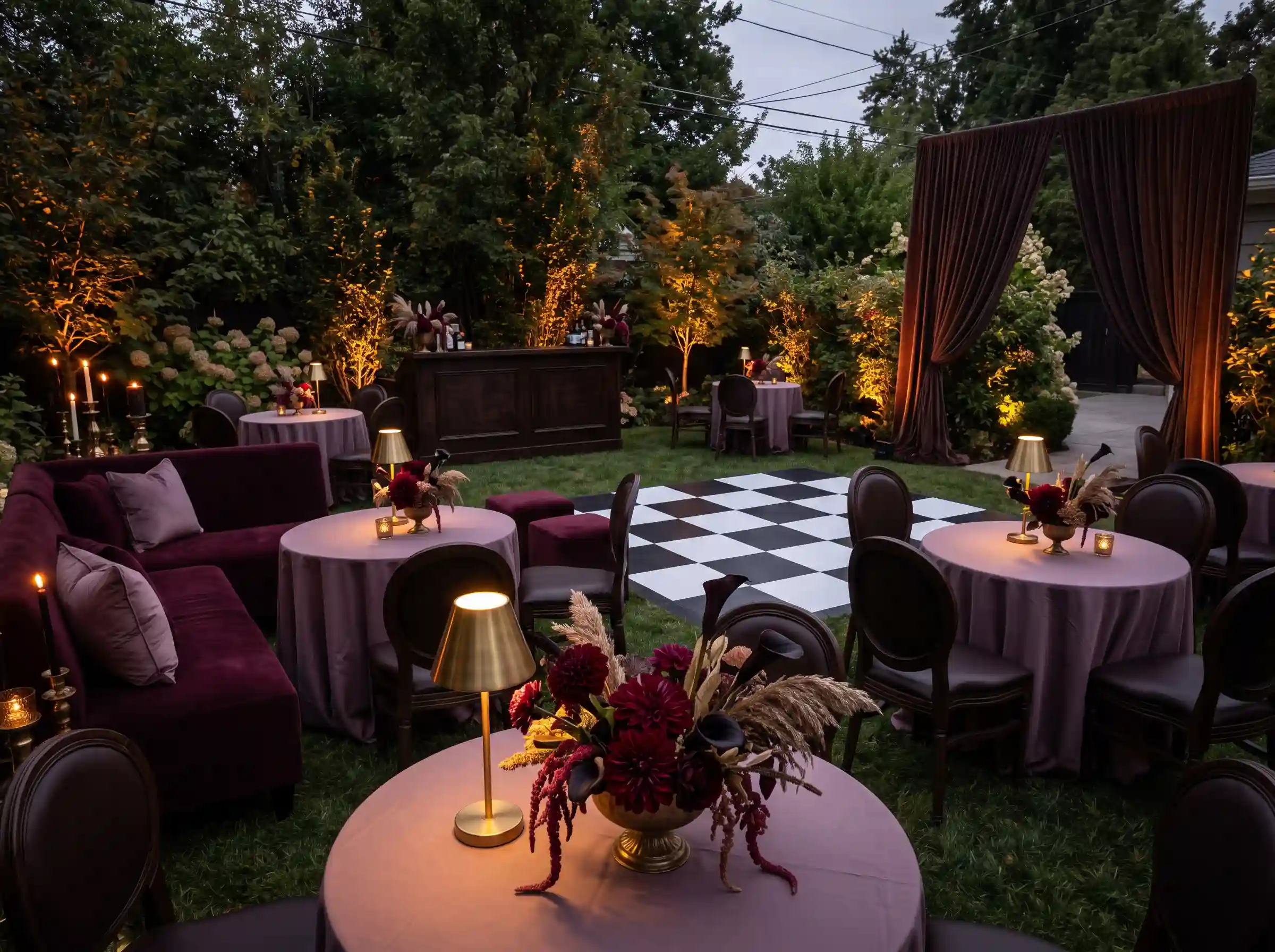 Moody speakeasy garden lounge reception with velvet seating brass accents and burgundy dahlias