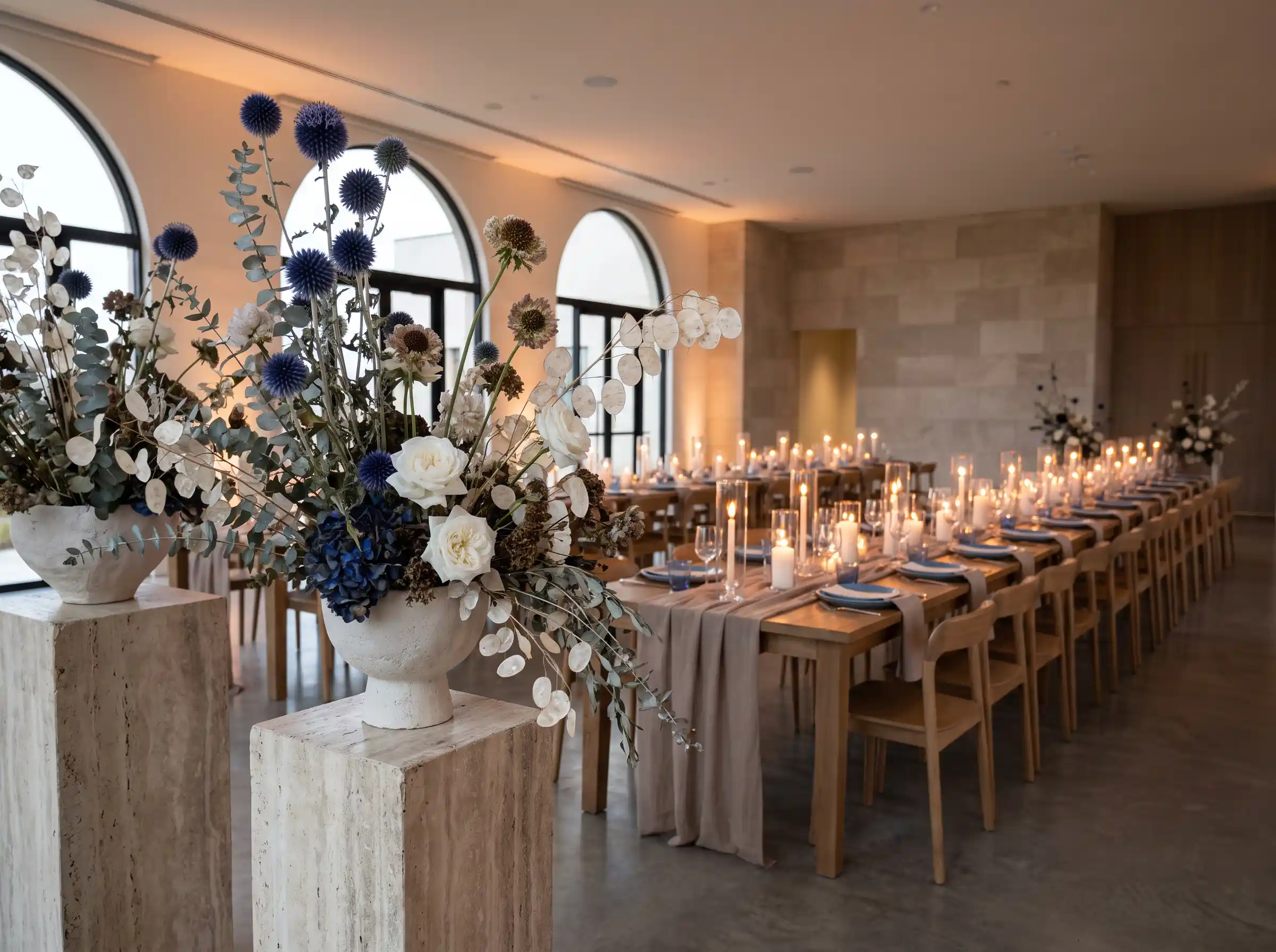 Deep indigo globe thistles with white garden roses and silvery eucalyptus in a modern romantic wedding display