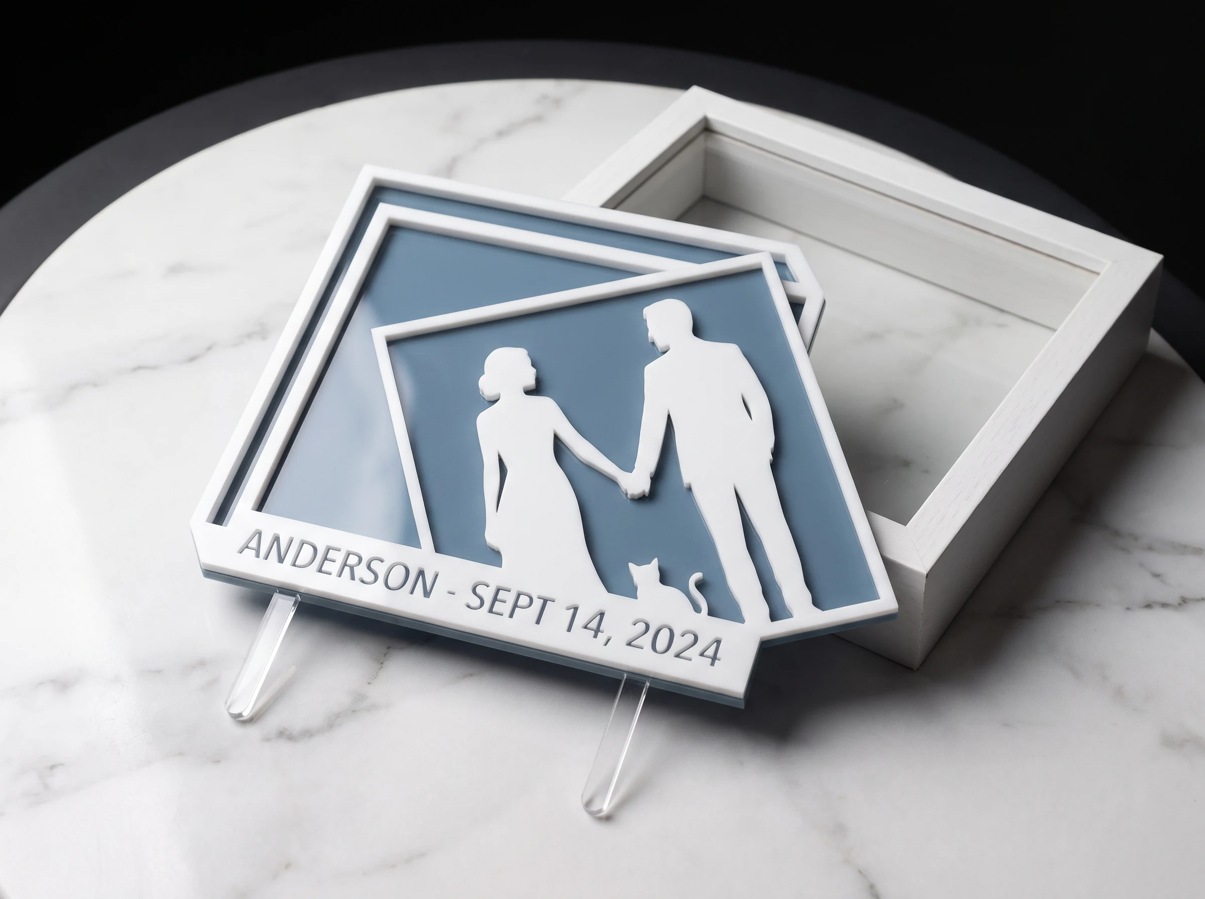 Laser-cut acrylic silhouette cake topper featuring couple with cat against dusty blue background
