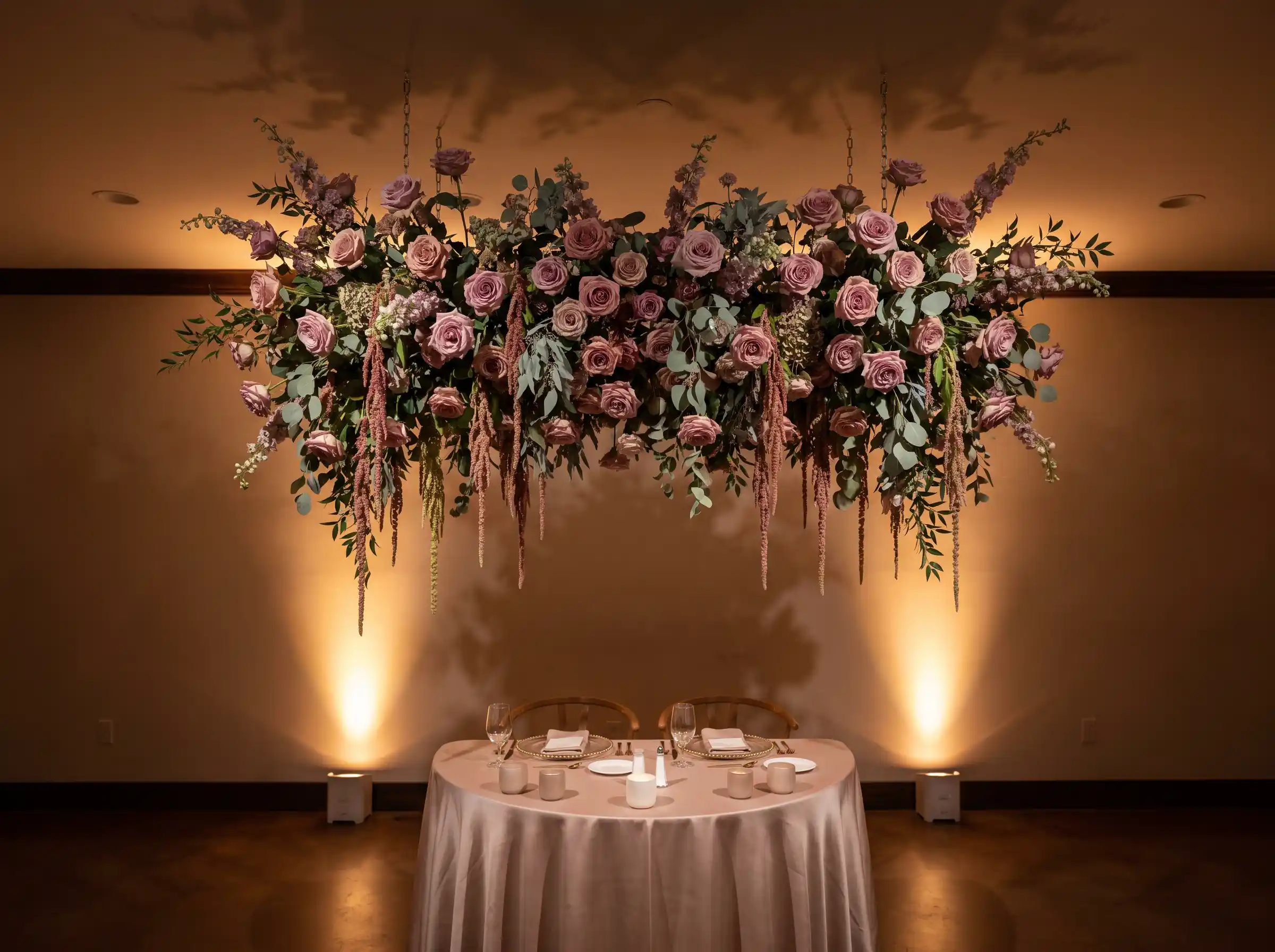 Dramatic suspended floral chandelier hanging over a wedding table with cascading blooms and greenery
