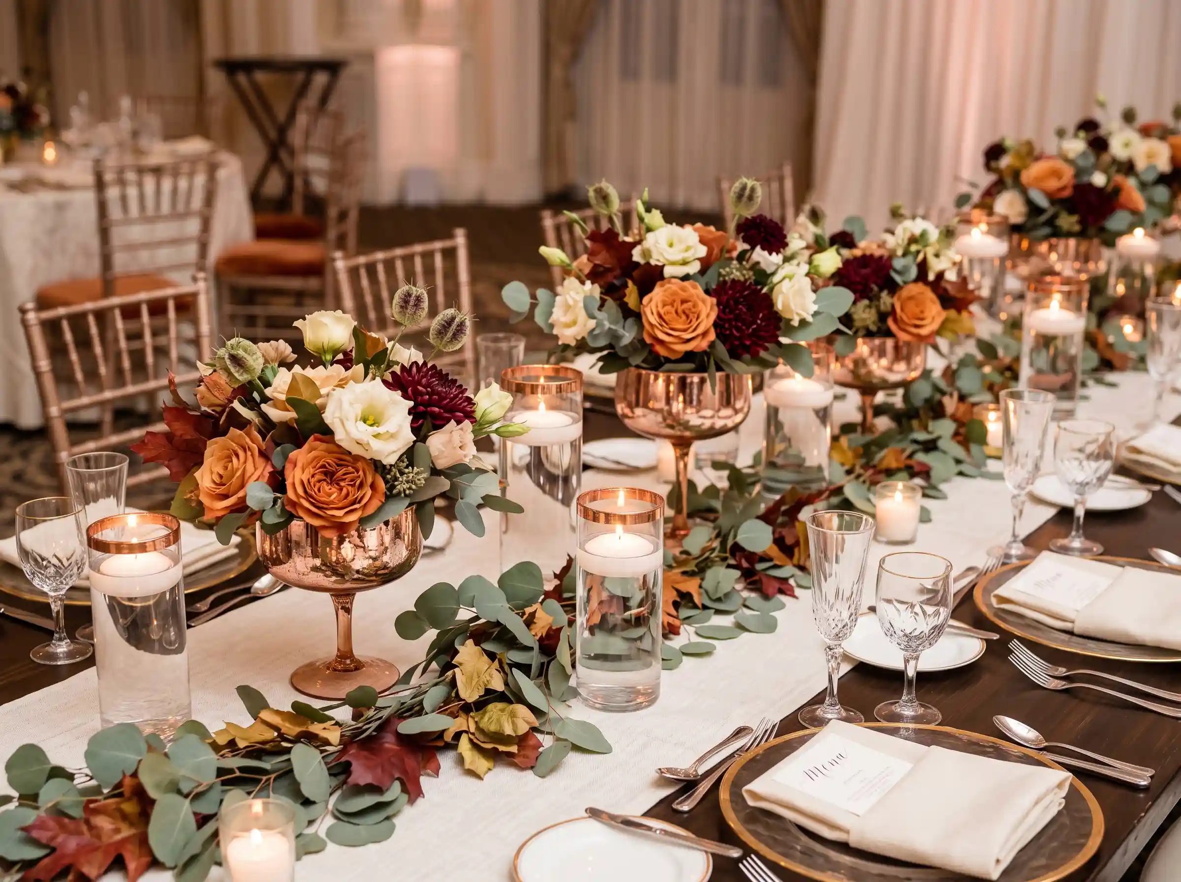 Romantic wedding centerpiece with copper accents and glass vessels filled with blush flowers